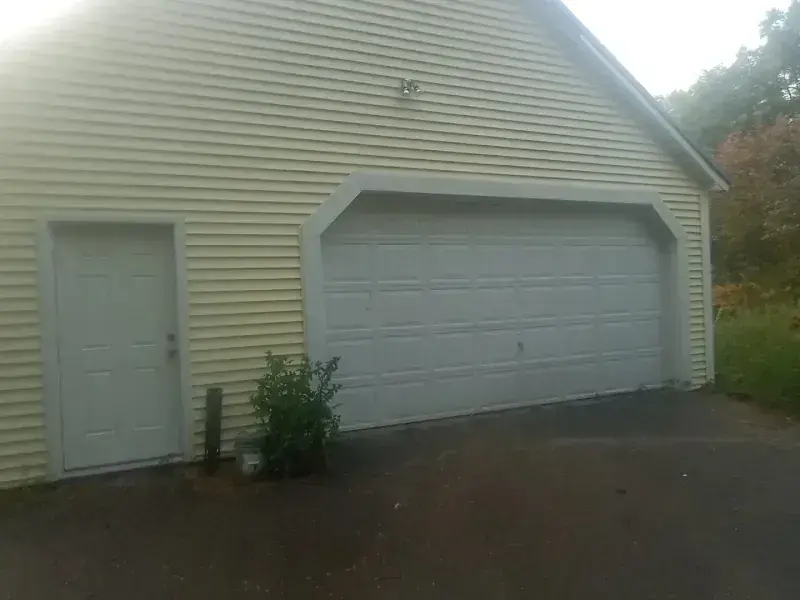 Dirty yellow siding beside a garage door, then the same wall and door cleaned