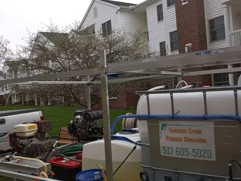 Shining Star Power Washing equipment trailer with the company name and phone number on the side, parked at a condominium job